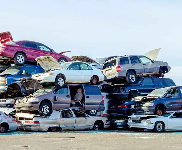 Stacked scrap cars in Arlington, TX for eco-friendly car part disposal service.