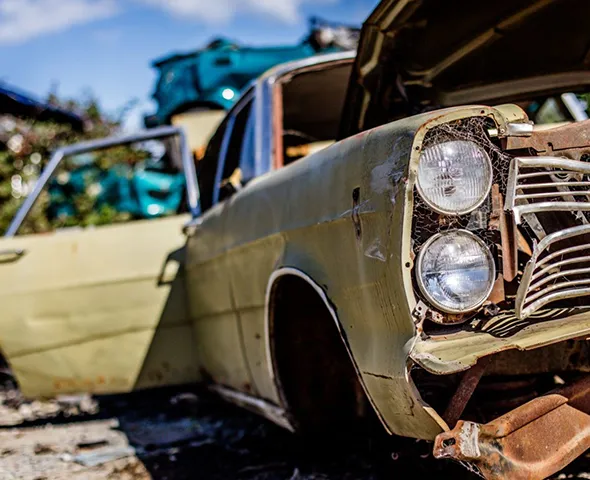 Old beige car with damaged front headlight for junk car removal in Red Oak, TX