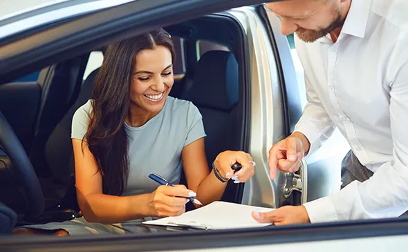 Car seller and buyer completing paperwork for fast car selling service in Irving, TX