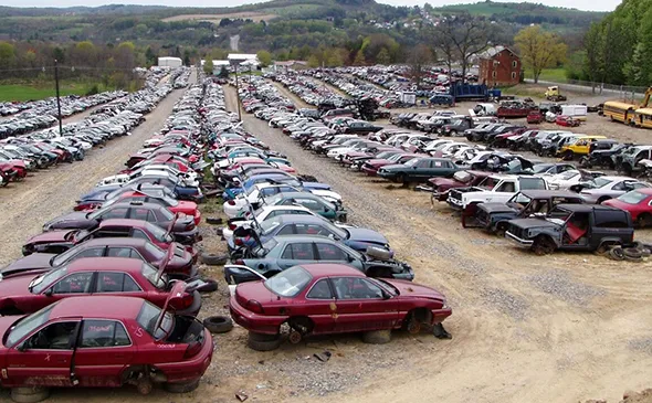 Large outdoor scrap yard full of junk cars in Midlothian TX for eco-friendly disposal.