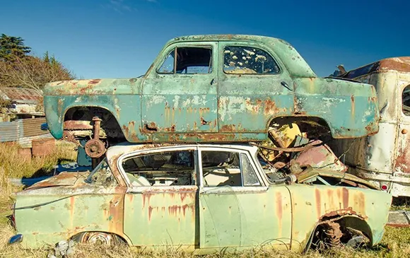 Rusty abandoned cars and truck in Arlington, TX for junk car dealer services.