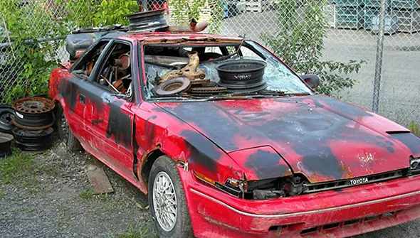 Rusty red and black junk car for quick car selling service in Red Oak, TX