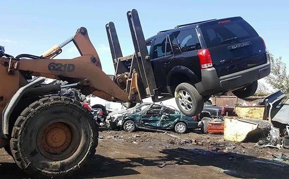 Heavy machinery handling junk cars for removal in Irving, TX