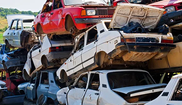 Multiple scrap cars stacked in a scrapyard, illustrating top scrap car removal services in Carleton, TX.