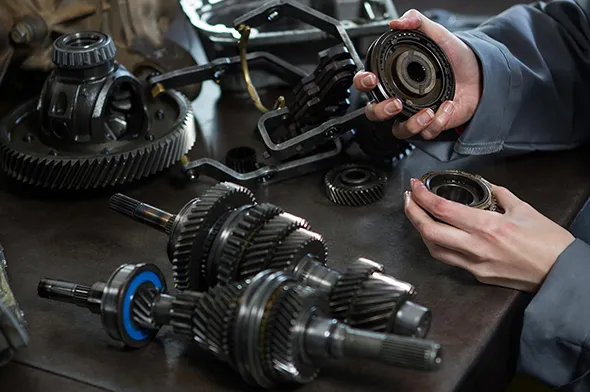 Mechanic inspecting car parts for trusted car part disposal service in Irving, TX